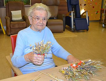 Frau Bernhard präsentiert stolz ihr gebundenes Sträußchen.