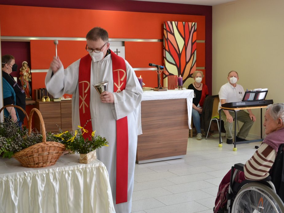 Ein Pfarrer steht in der Kapelle.